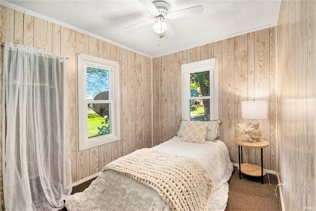 carpeted bedroom featuring ornamental molding, ceiling fan, a textured ceiling, and baseboards