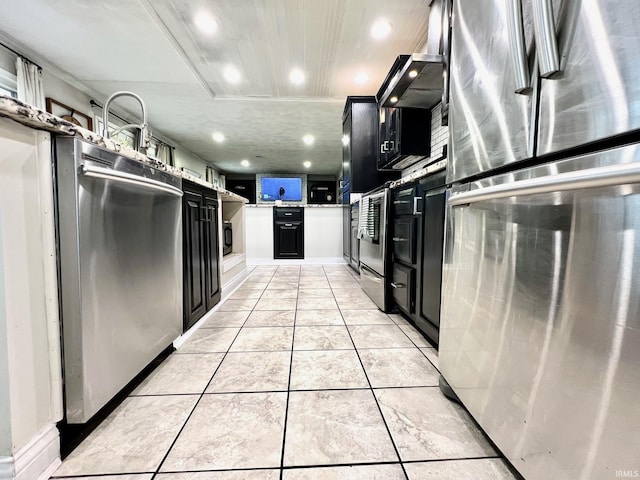 kitchen with light tile patterned floors, freestanding refrigerator, and dark cabinets