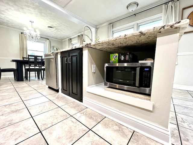 kitchen featuring refrigerator, light tile patterned floors, an inviting chandelier, ornamental molding, and dark cabinets