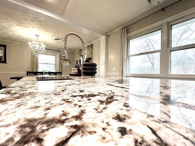 kitchen featuring a chandelier, light stone counters, a sink, marble finish floor, and crown molding