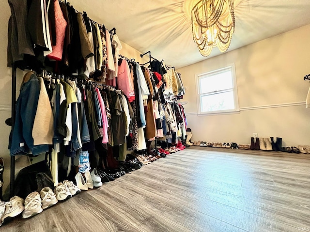 walk in closet featuring a chandelier and wood finished floors