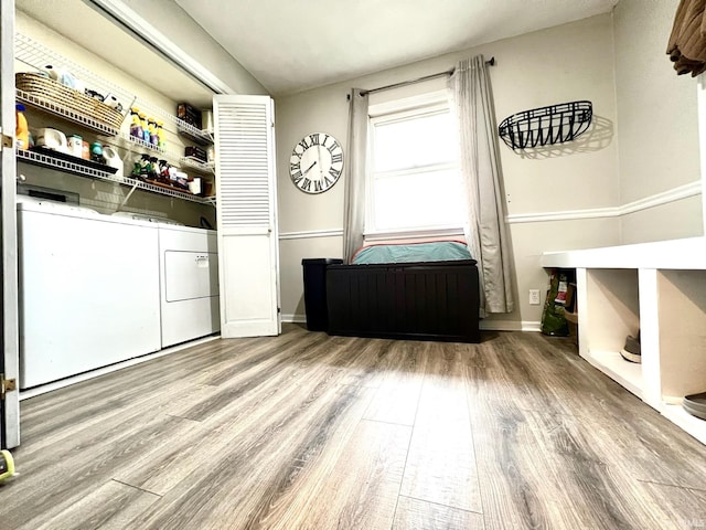 washroom featuring laundry area, baseboards, washer and dryer, and wood finished floors