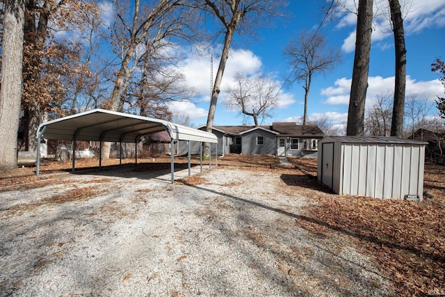 exterior space featuring a detached carport, an outbuilding, dirt driveway, and a storage shed