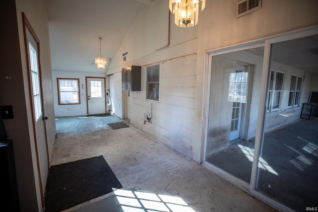 interior space featuring high vaulted ceiling, visible vents, and an inviting chandelier