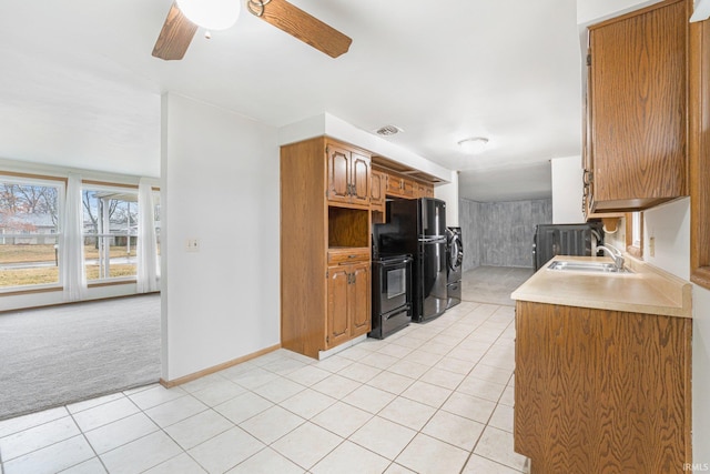 kitchen with light tile patterned flooring, light carpet, a sink, visible vents, and light countertops