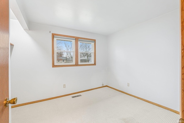 spare room with carpet, visible vents, and baseboards