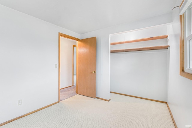 unfurnished bedroom with carpet floors, baseboards, and a closet