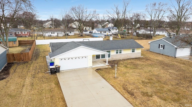 view of front of home with concrete driveway, fence, a garage, a residential view, and a front lawn