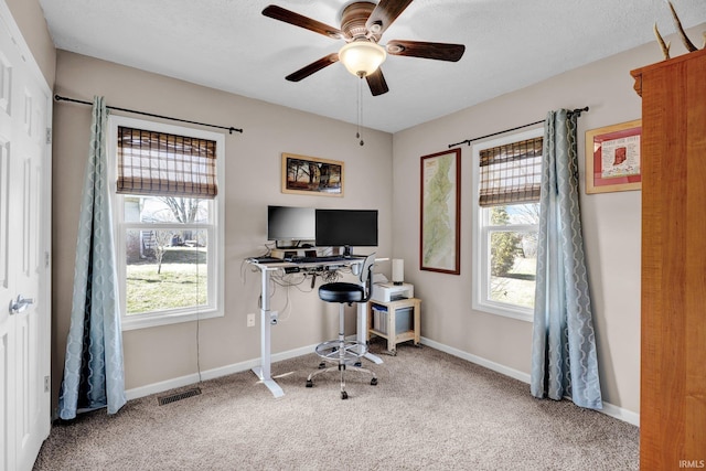 carpeted office featuring a textured ceiling, a ceiling fan, visible vents, and baseboards