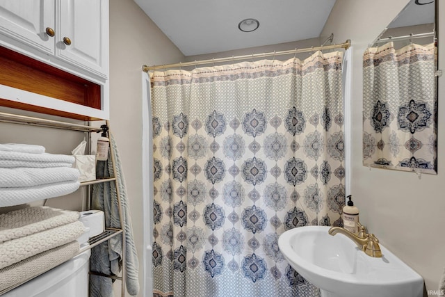 bathroom with a shower with curtain and a sink