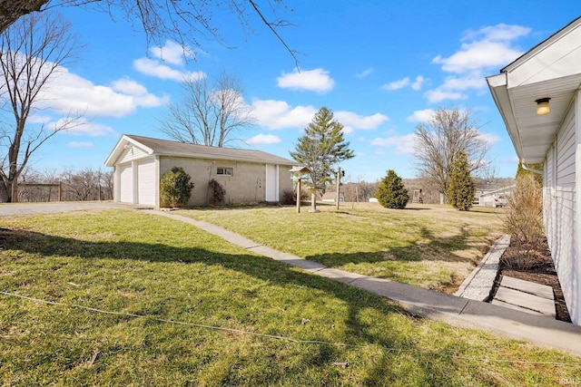 view of yard featuring a garage and an outbuilding