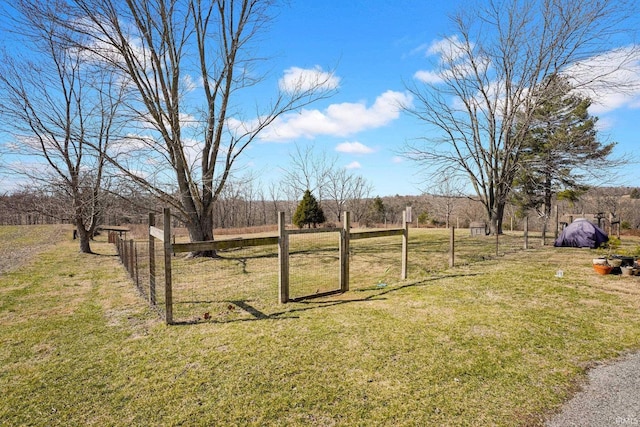 view of yard featuring a gate, fence, and a rural view