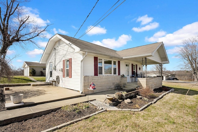 view of side of home featuring covered porch and a yard