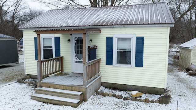 bungalow-style home with an outbuilding and metal roof