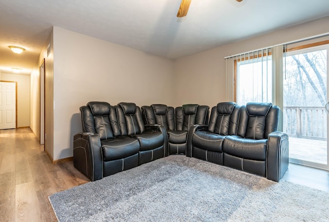 cinema room featuring baseboards, ceiling fan, and wood finished floors