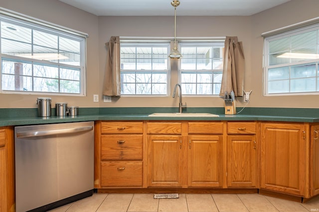 kitchen featuring stainless steel dishwasher, brown cabinetry, and a sink