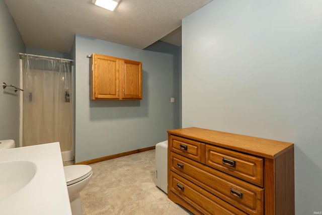 bathroom with a shower with curtain, toilet, baseboards, and a sink