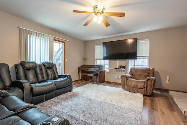 living area with baseboards, ceiling fan, and wood finished floors