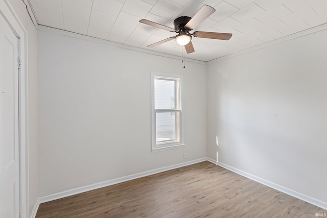 unfurnished room featuring a ceiling fan, baseboards, and wood finished floors