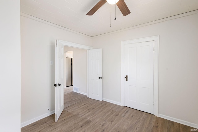 unfurnished bedroom featuring baseboards, visible vents, light wood finished floors, and stainless steel refrigerator