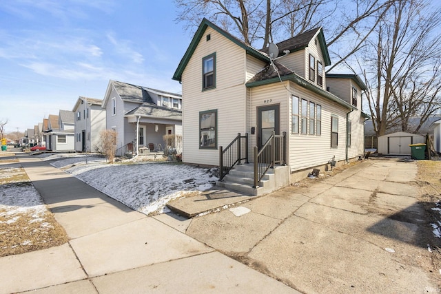 view of front of house featuring a shed, a residential view, and an outdoor structure