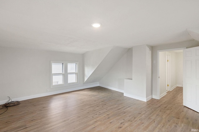 additional living space with light wood-style flooring and baseboards