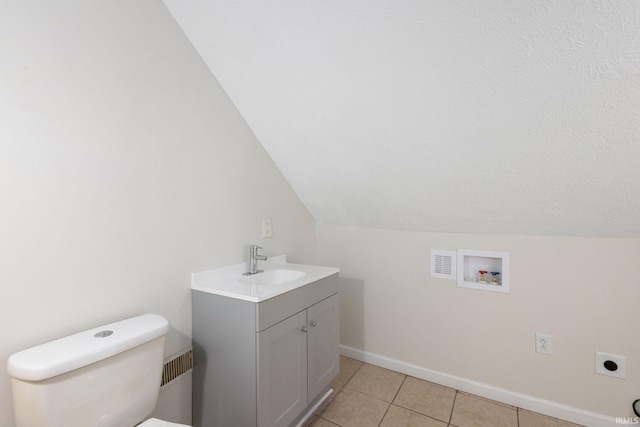 bathroom with toilet, visible vents, baseboards, vanity, and tile patterned floors