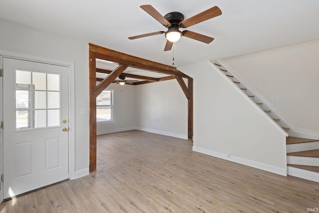 foyer entrance with light wood-style floors, stairs, baseboards, and a ceiling fan