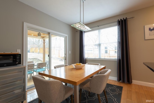 dining area featuring light wood finished floors and baseboards