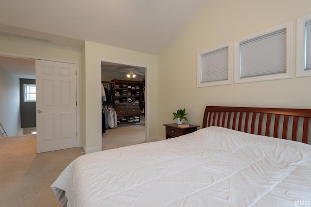 bedroom with baseboards, lofted ceiling, carpet, a spacious closet, and a closet