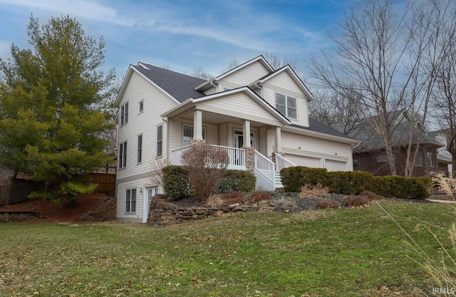 view of front of property featuring a front yard, covered porch, and an attached garage