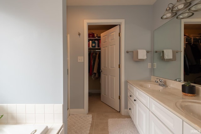 bathroom featuring double vanity, a tub to relax in, a sink, and tile patterned floors