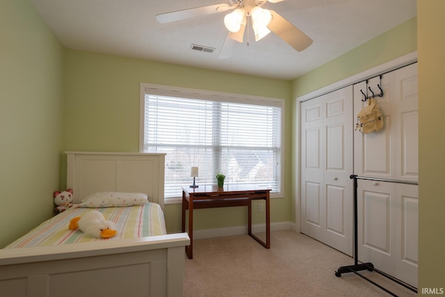 bedroom with a closet, visible vents, light carpet, ceiling fan, and baseboards