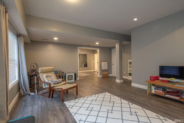 living area featuring baseboards, wood finished floors, and recessed lighting