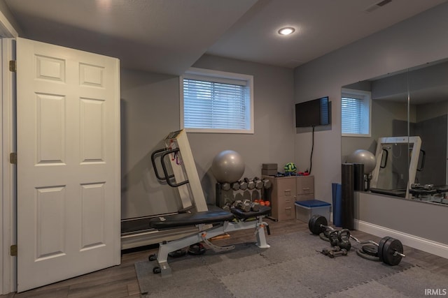 workout room with visible vents, baseboards, and wood finished floors