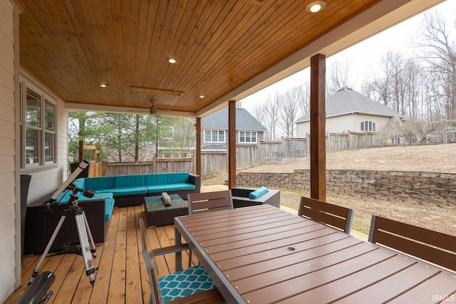 wooden terrace with an outdoor hangout area, outdoor dining area, and a fenced backyard