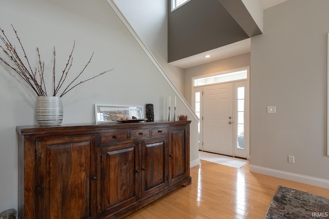 foyer entrance with light wood-style floors and baseboards