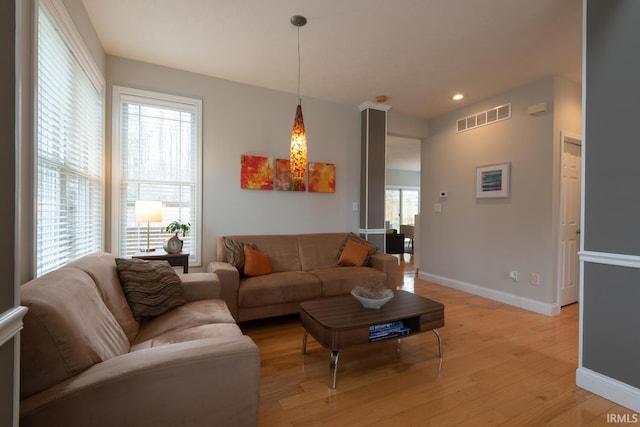 living area featuring recessed lighting, light wood-type flooring, visible vents, and baseboards