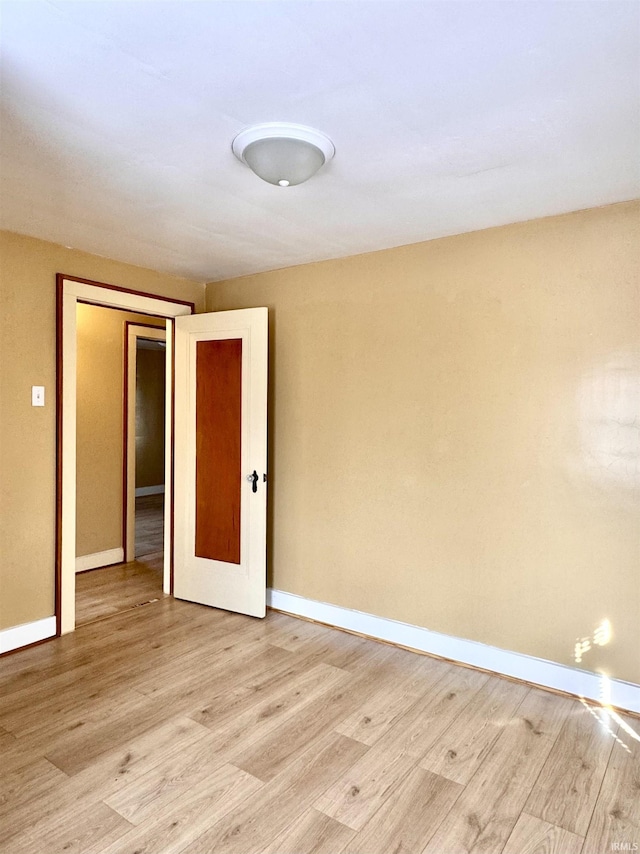 spare room with light wood-style flooring and baseboards