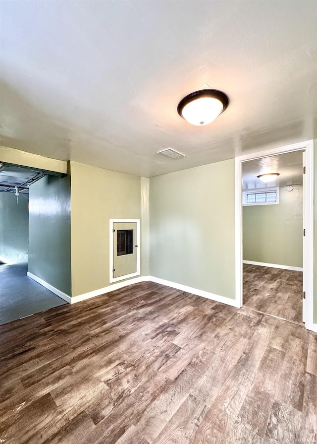 empty room featuring wood finished floors and baseboards