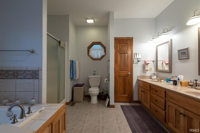 bathroom with double vanity, a stall shower, toilet, tile patterned floors, and a sink