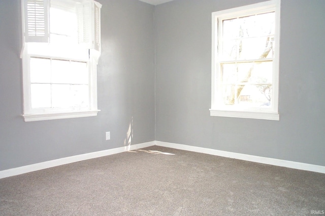 empty room with a healthy amount of sunlight, carpet flooring, and baseboards