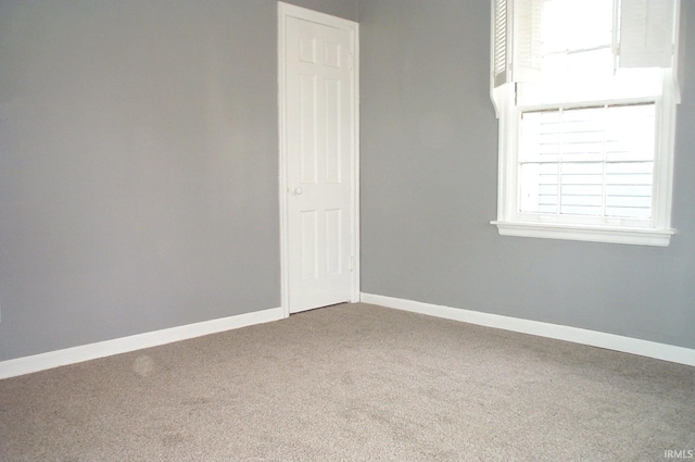 carpeted spare room with baseboards