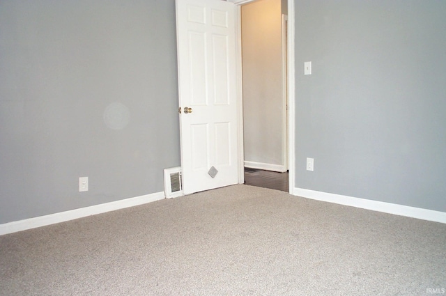 carpeted empty room featuring baseboards and visible vents