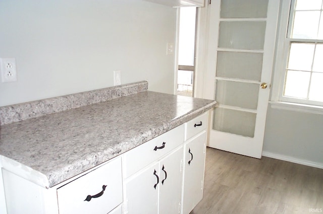 interior space with light countertops, white cabinets, and light wood-style floors