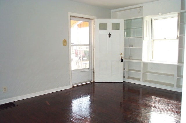 interior space with visible vents, baseboards, and wood finished floors