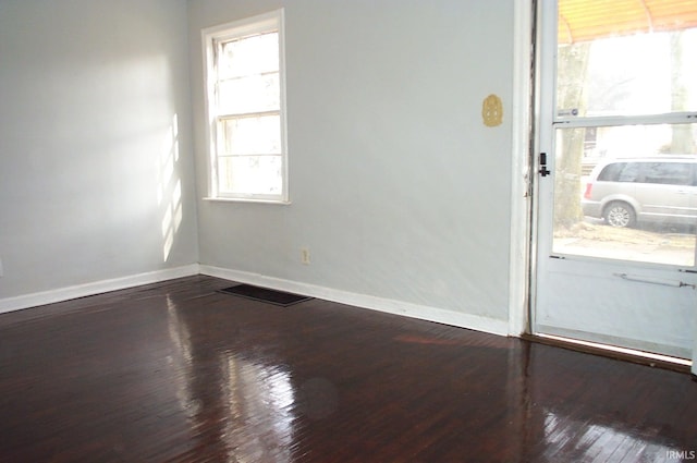 unfurnished room with dark wood finished floors and baseboards