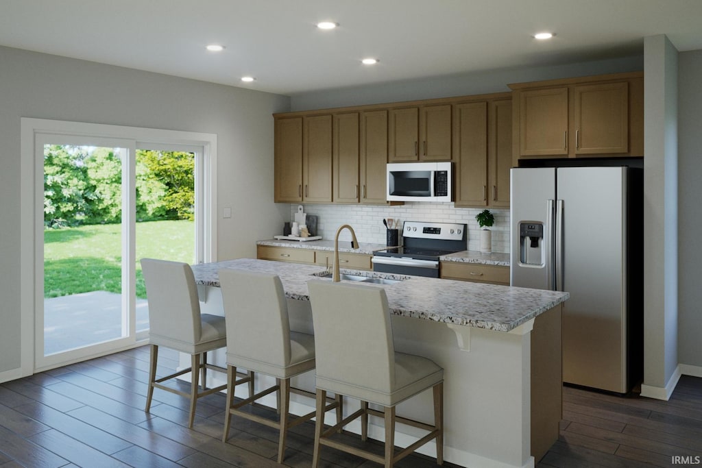 kitchen featuring dark wood finished floors, a center island with sink, tasteful backsplash, appliances with stainless steel finishes, and a sink