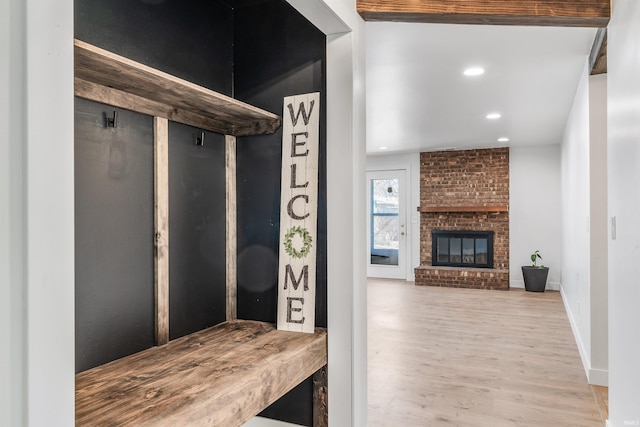 mudroom featuring a brick fireplace, baseboards, wood finished floors, and recessed lighting