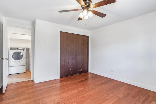 unfurnished bedroom with washer / dryer, baseboards, and light wood finished floors